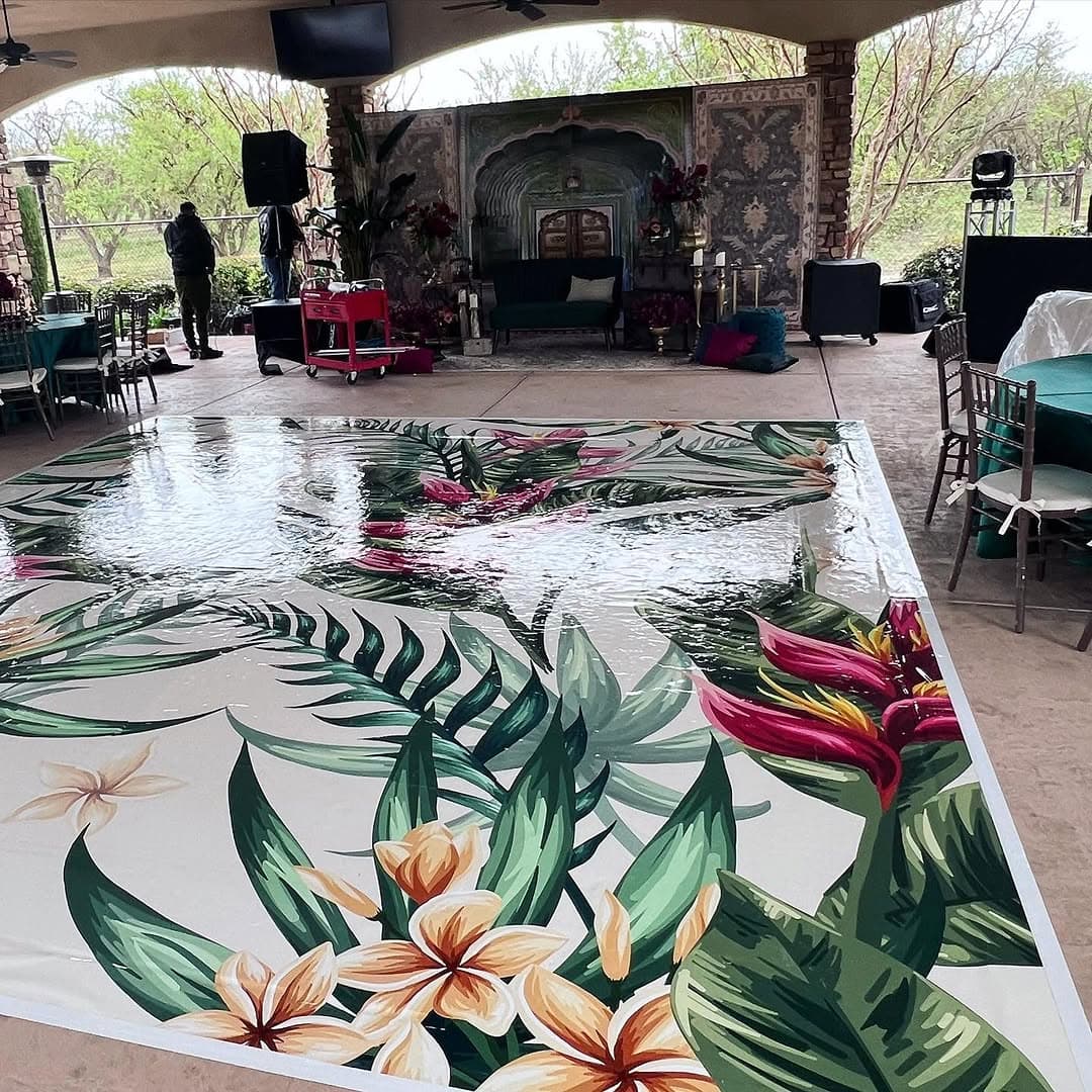 Tropical palm and plumeria dance floor rental installed under an open-air pavilion for a private party