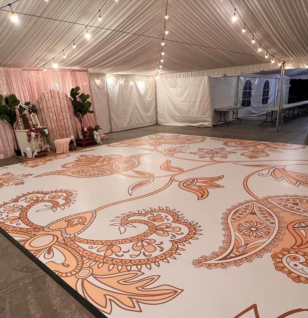 Henna-inspired paisley dance floor rental filling a draped tent reception