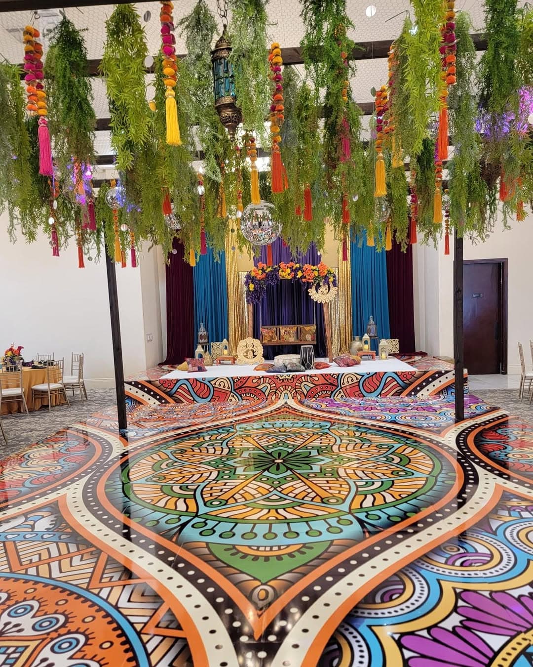 Vibrant mandala dance floor rental in turquoise, orange and magenta for a sangeet celebration