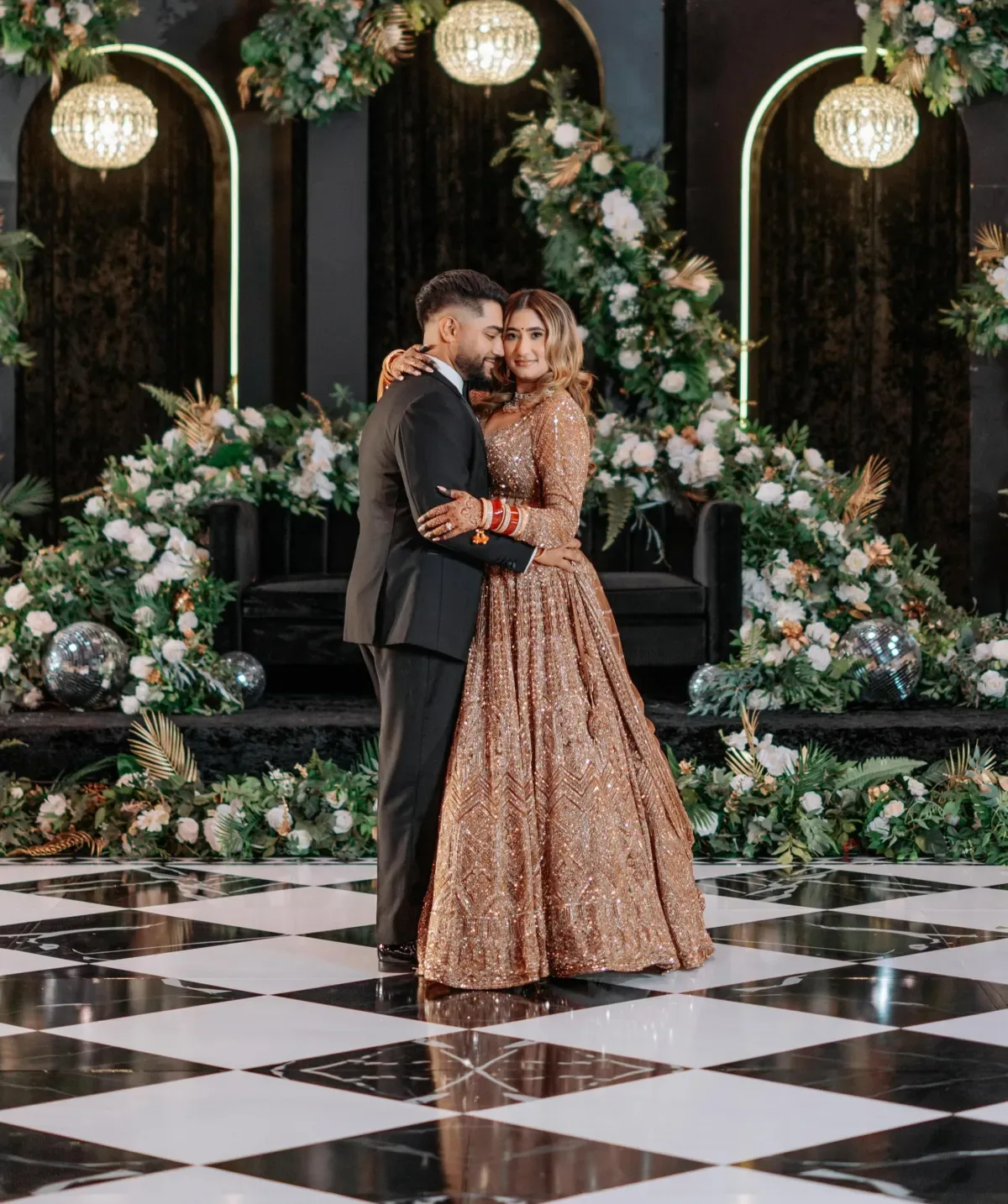 Couple dancing on a custom checkered dance floor rental at a luxury reception